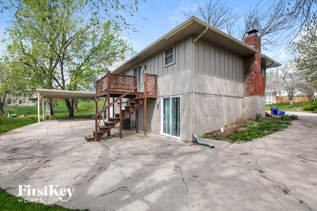the front of a house with a driveway and a deck