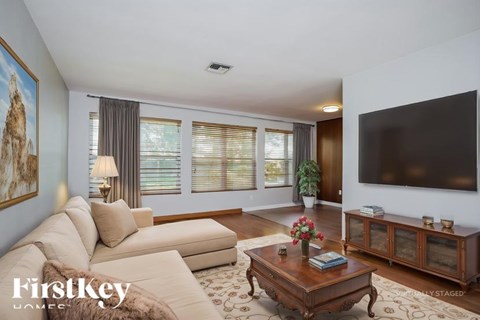 A living room with a sofa, a coffee table, and a painting on the wall.