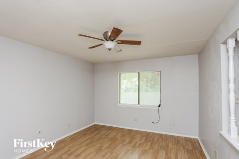 A room with a ceiling fan and a window.