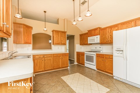 A kitchen with wooden cabinets and white appliances.
