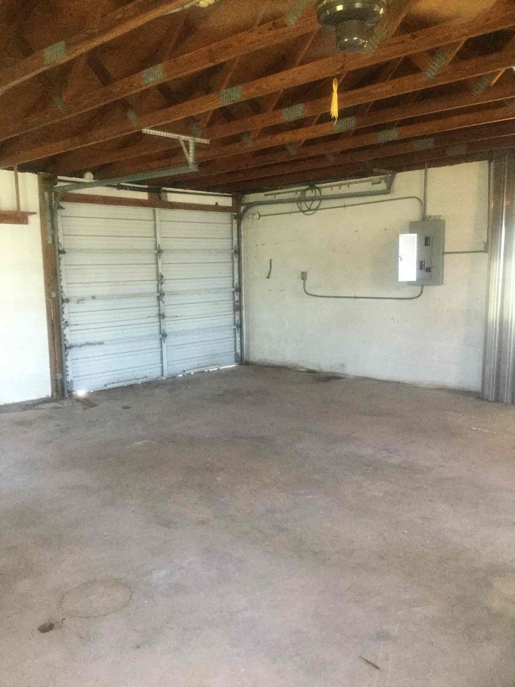 the inside of a garage with white walls and a fan