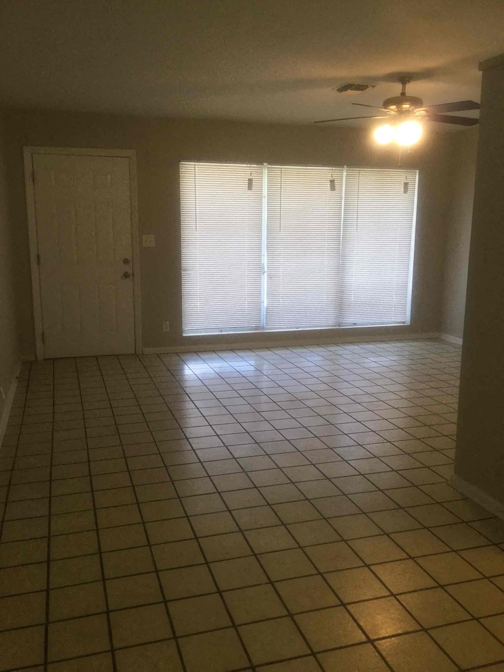 an empty living room with a tiled floor