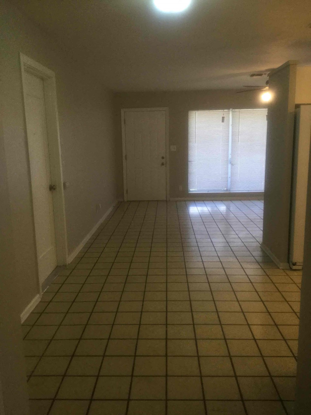 an empty living room with a tiled floor