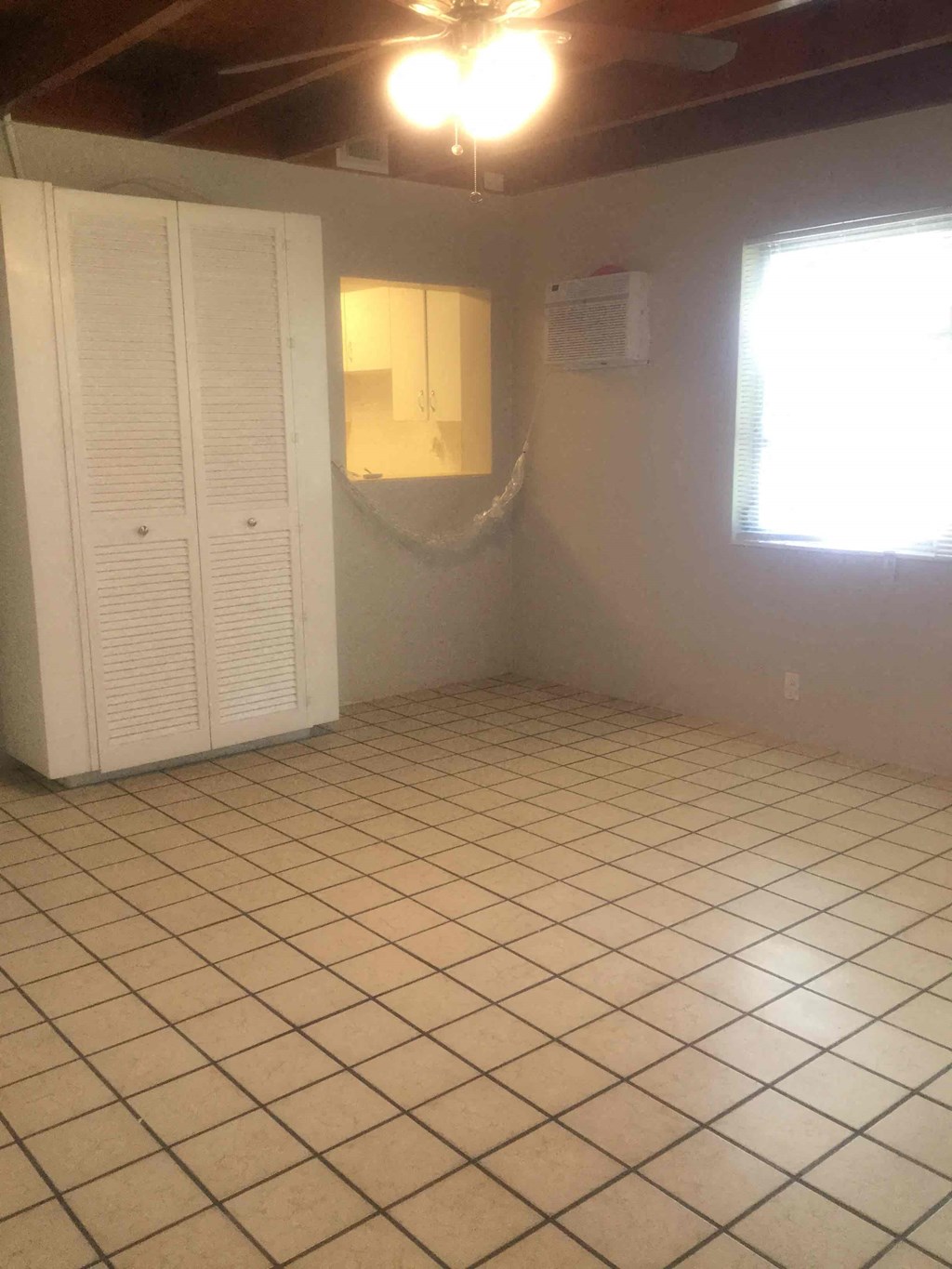 an empty room with a tiled floor and a closet