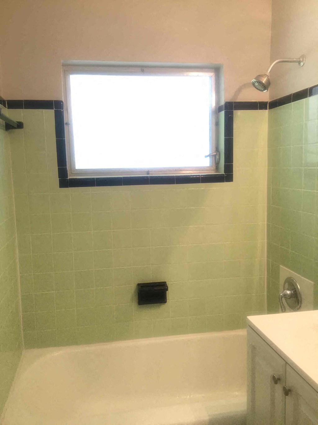 a bathroom with a tub and a window and a sink