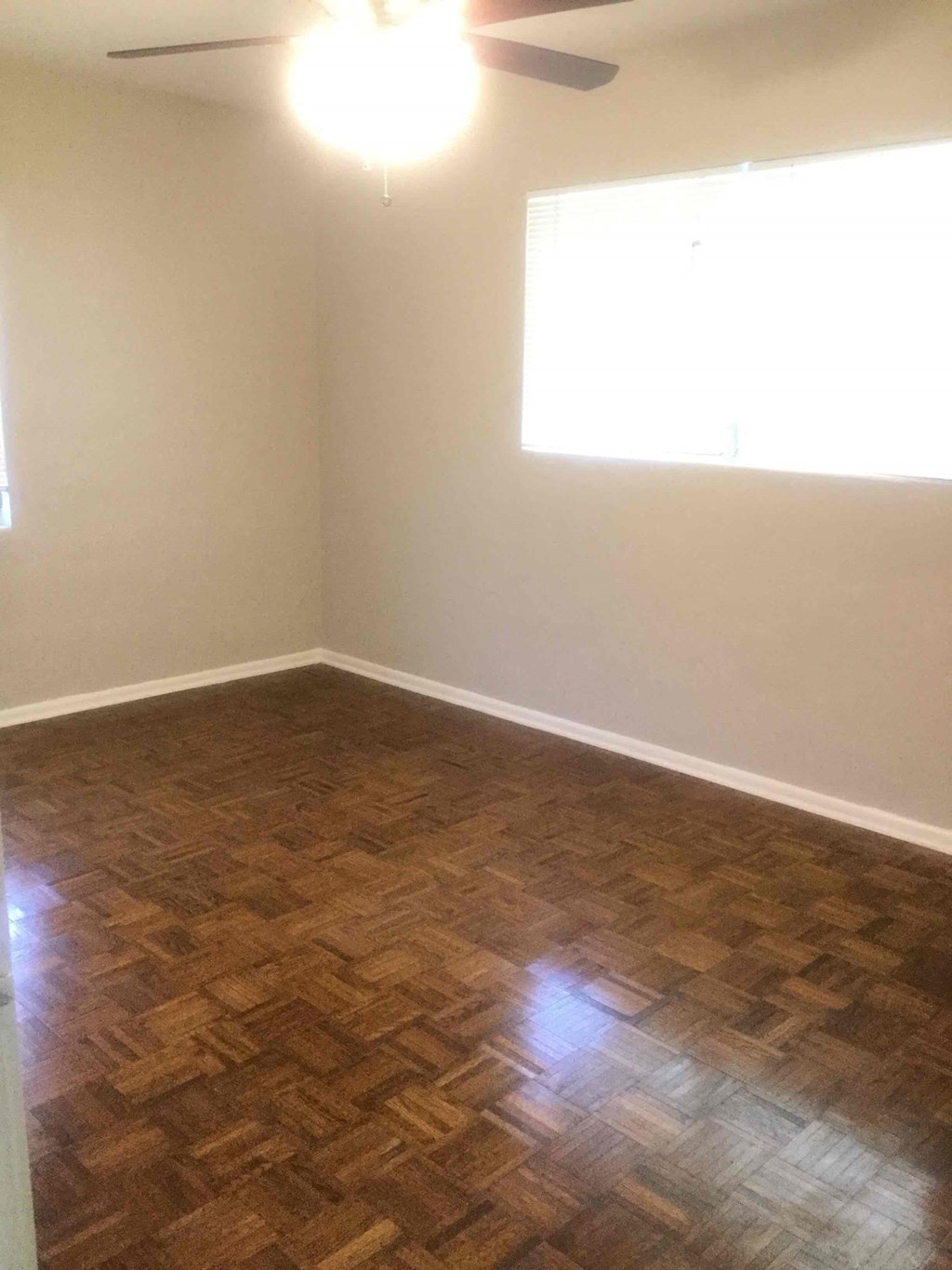 an empty room with wooden floors and a window