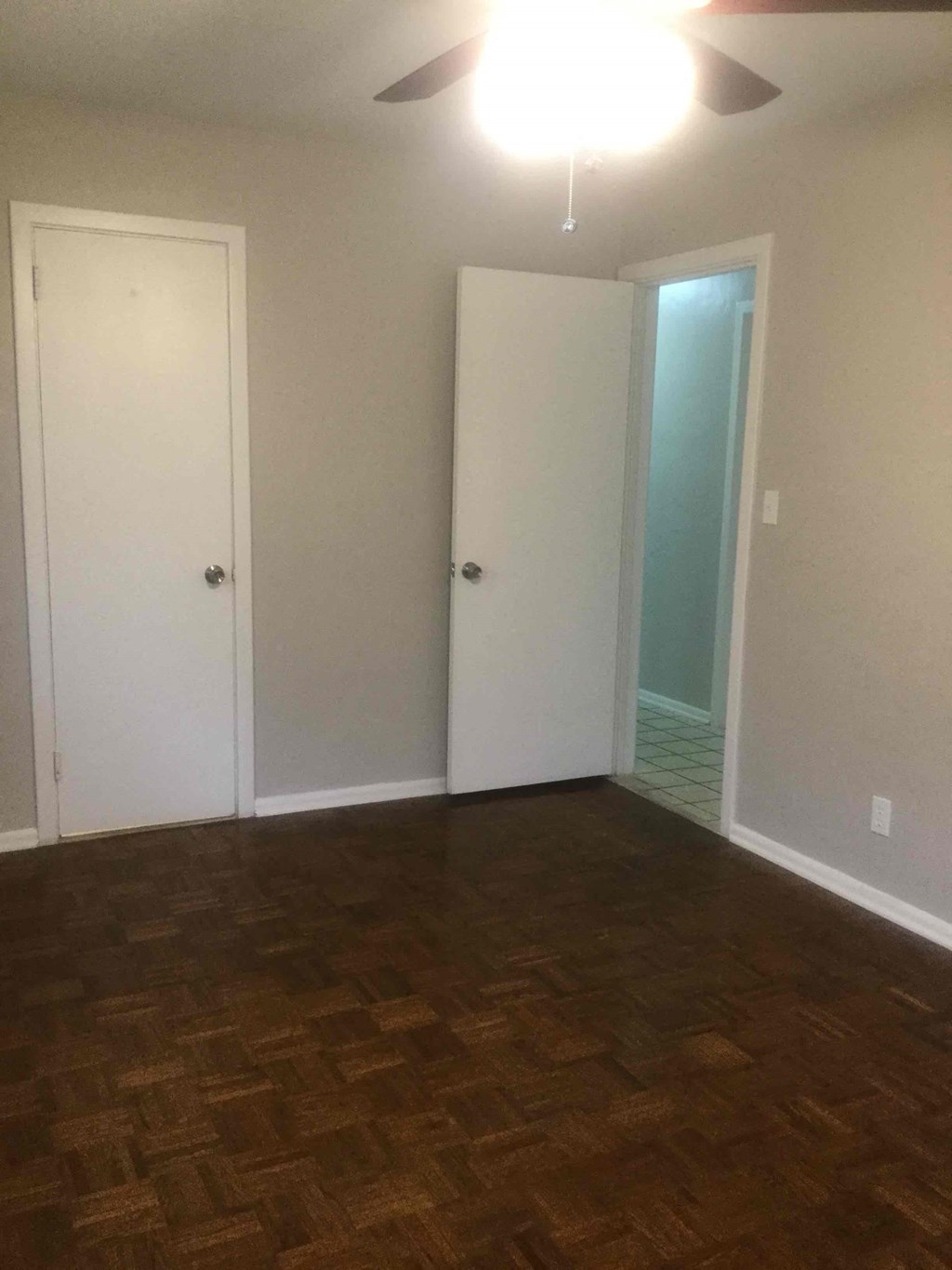 an empty living room with a hard wood floor and white walls