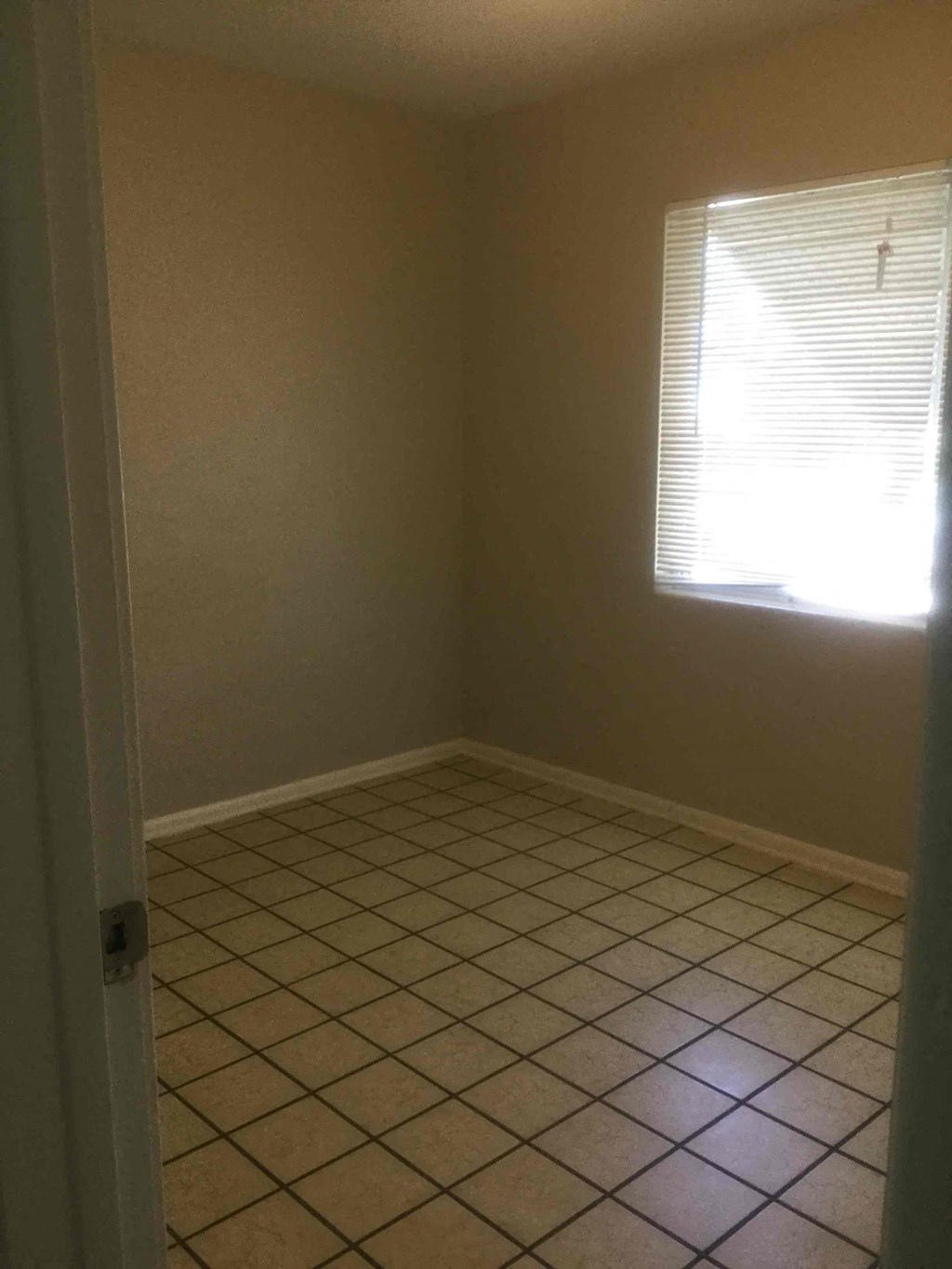 an empty room with a tiled floor and a window