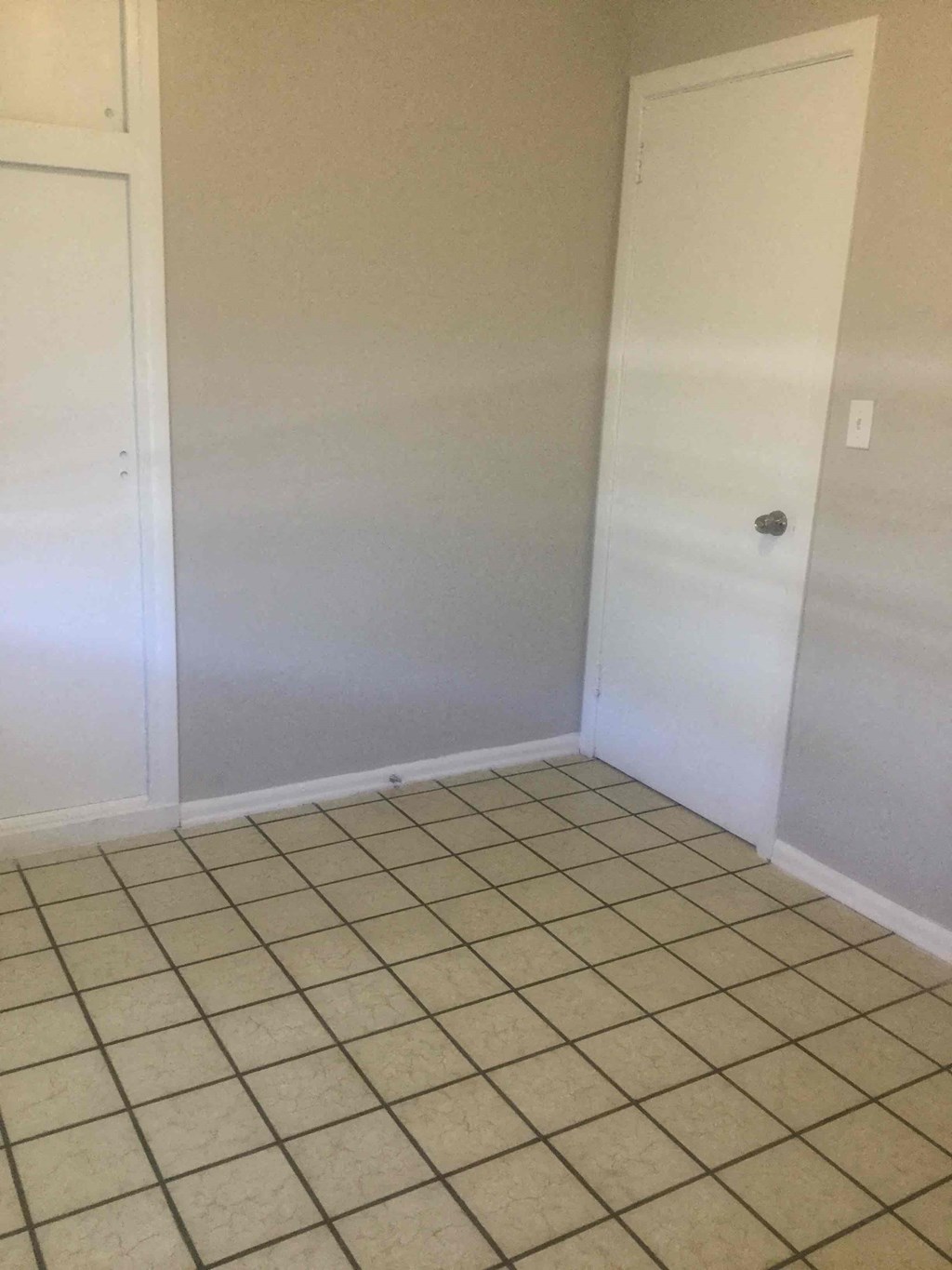 an empty room with a tiled floor and a closet
