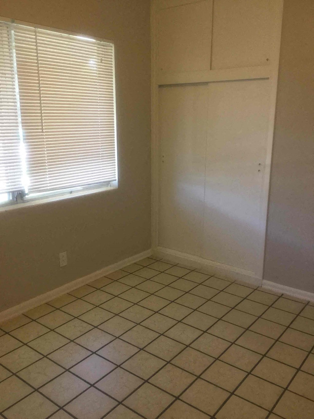 an empty room with a closet and a tiled floor