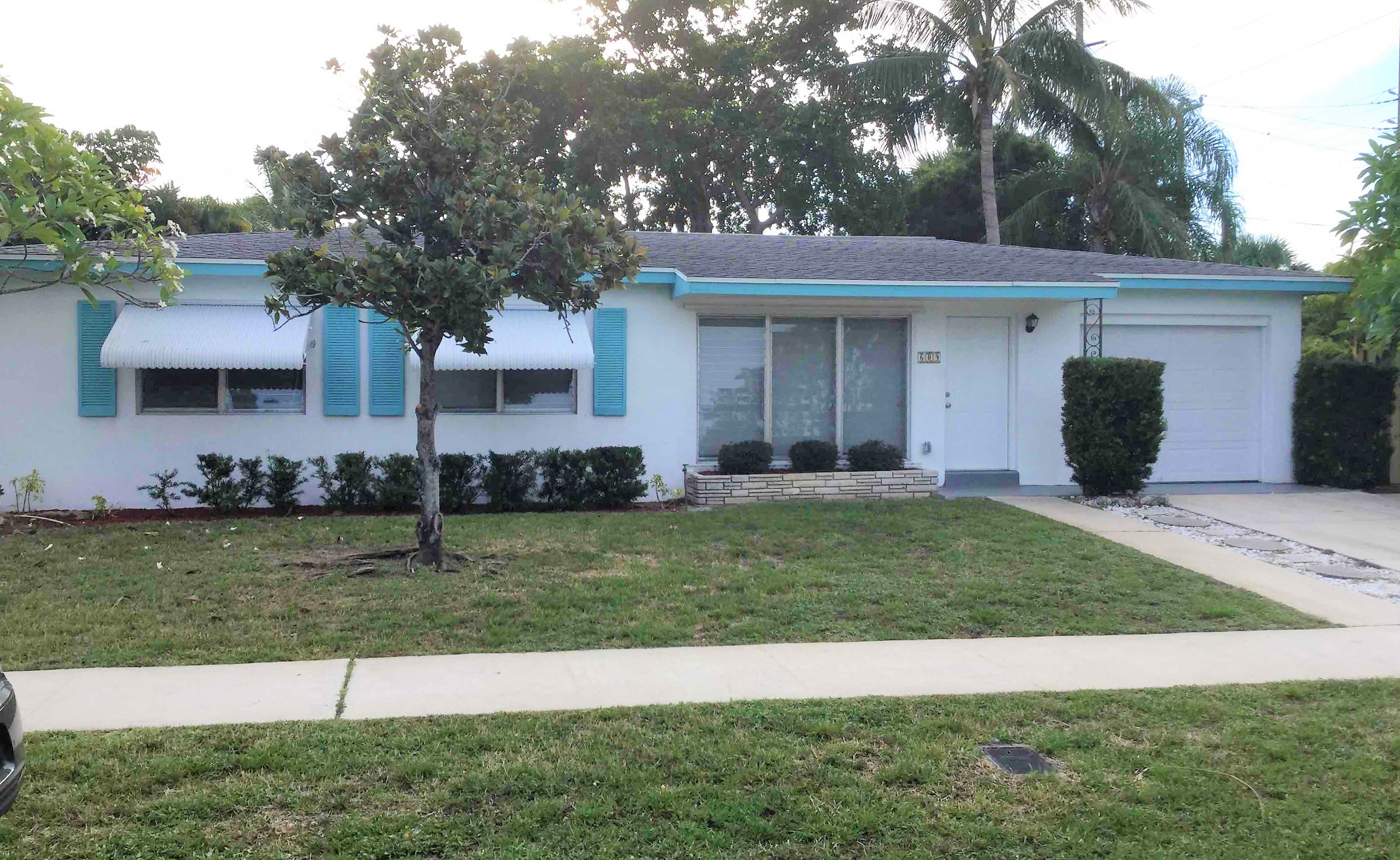 a white house with blue shutters and a lawn