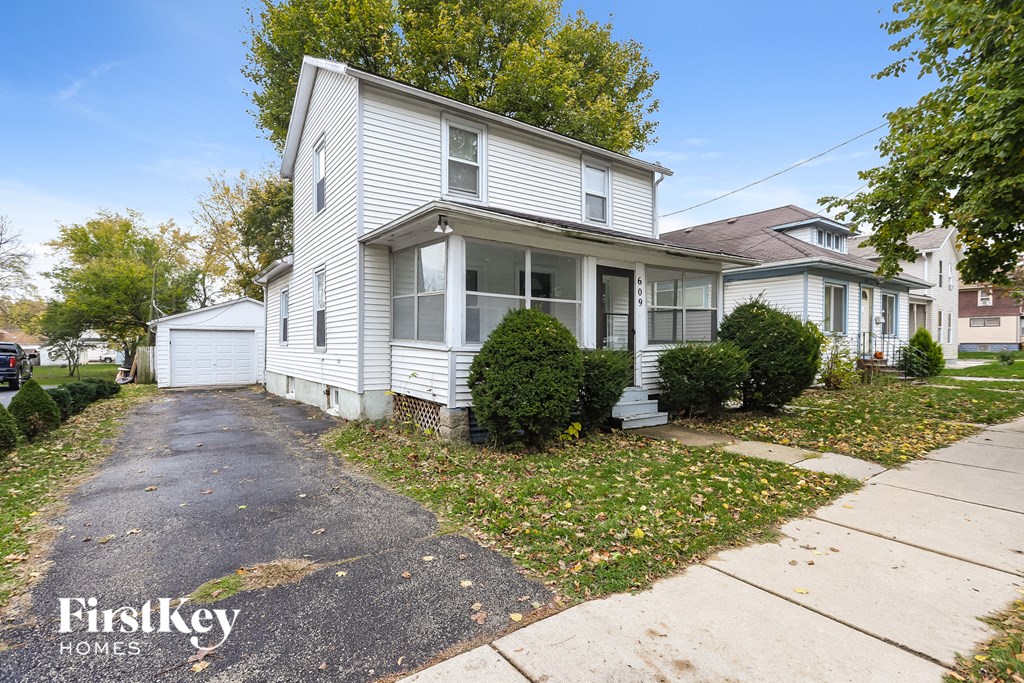 A white house with a driveway in front of it.