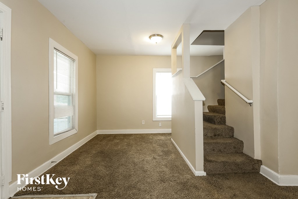 A room with a staircase leading to another room.