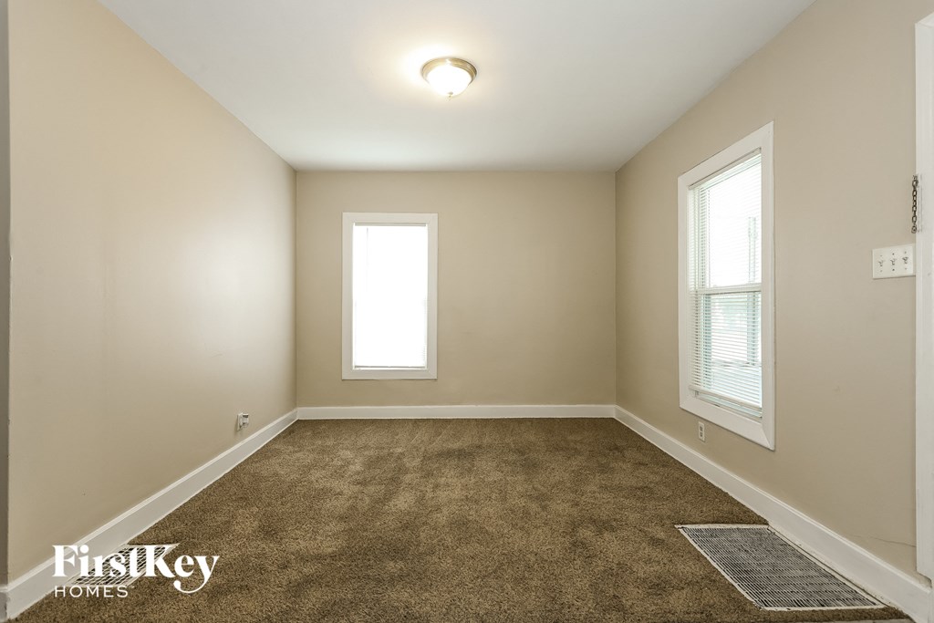 A room with a carpeted floor and a window.