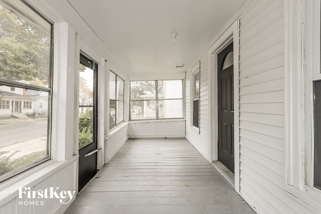 A white house with a balcony and a door.