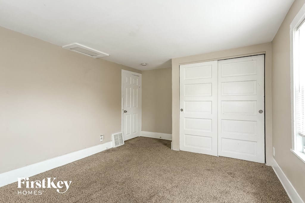 A room with a carpeted floor and a white door.