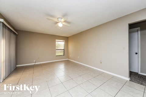 A spacious room with a ceiling fan and a window.