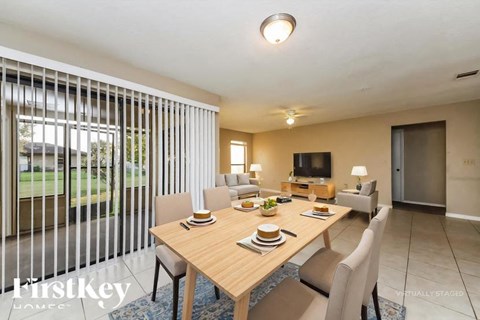 A dining room with a wooden table set for two.