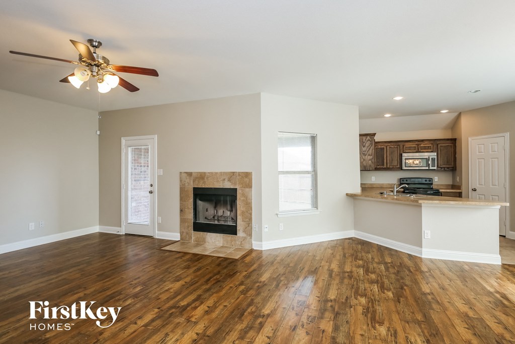 a living room with a fireplace and a kitchen