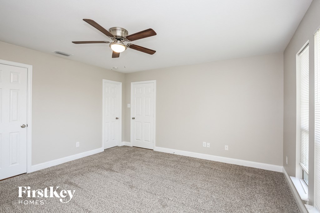the living room of an empty home with a ceiling fan