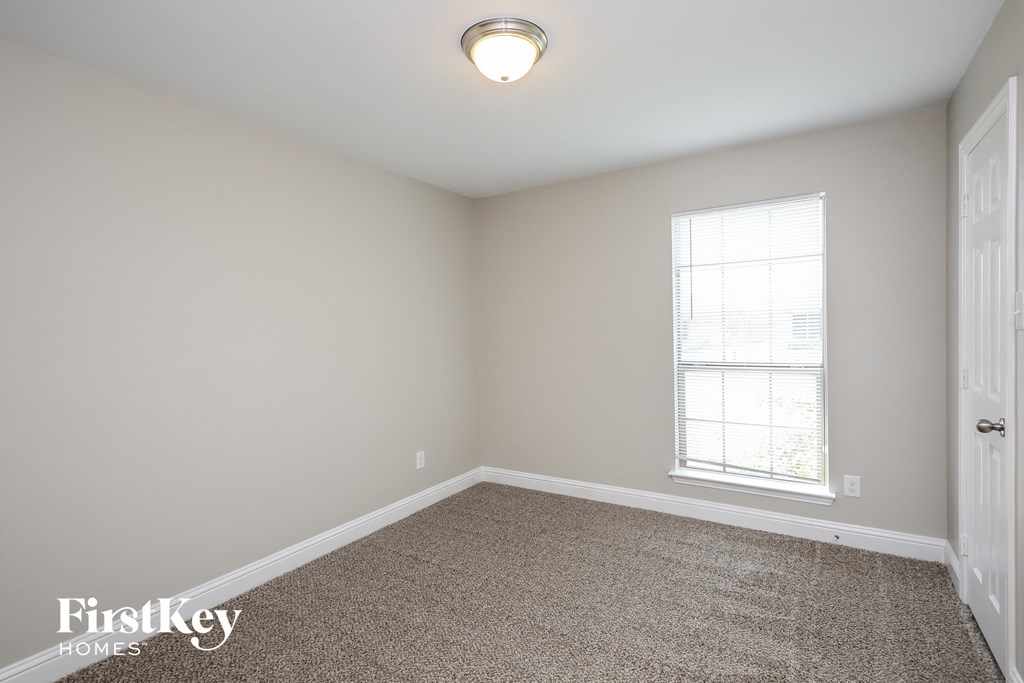 a empty room with carpet and a window