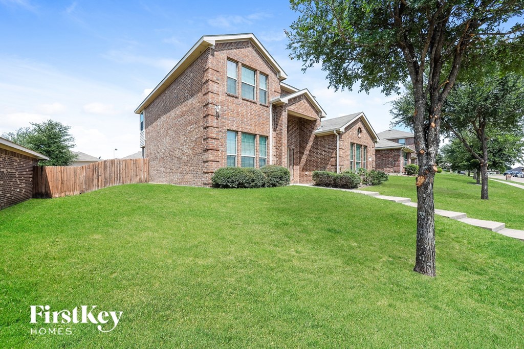 A brick house with a tree in front of it.