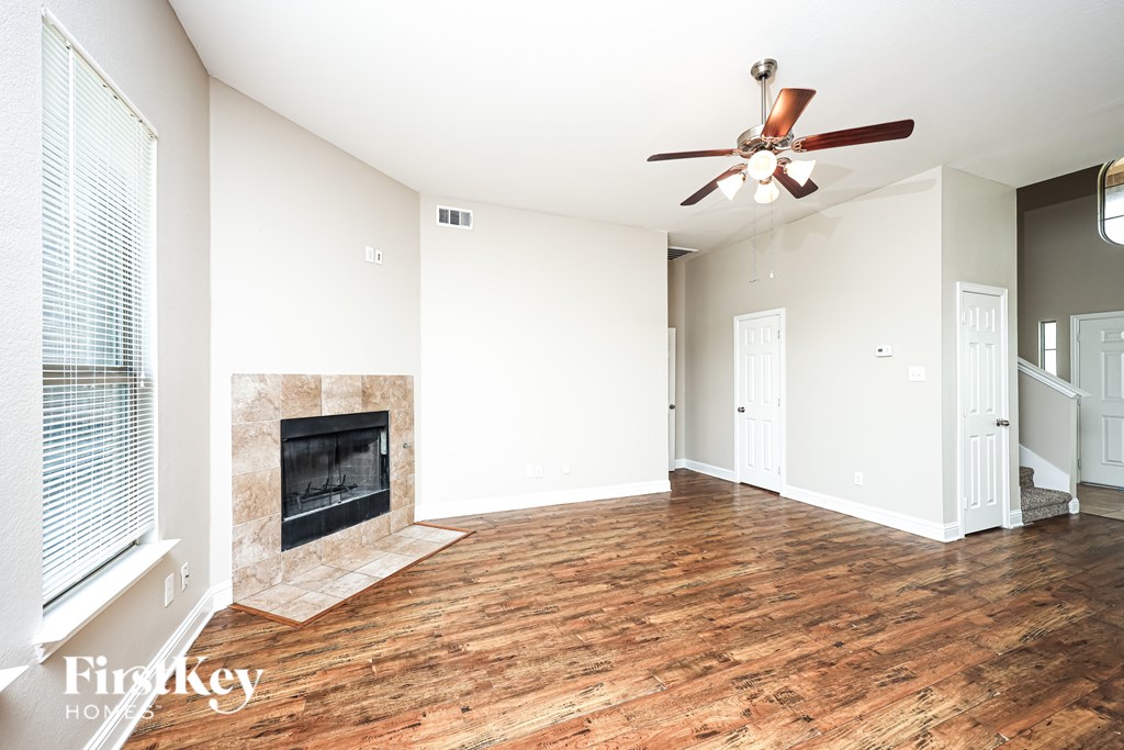 A room with a fireplace and a ceiling fan.