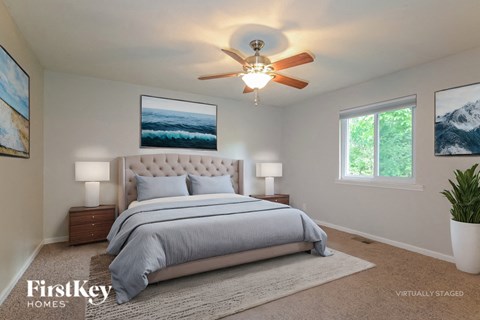 A bedroom with a large bed and a ceiling fan.