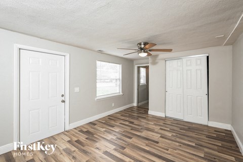 a living room with wood floors and a ceiling fan