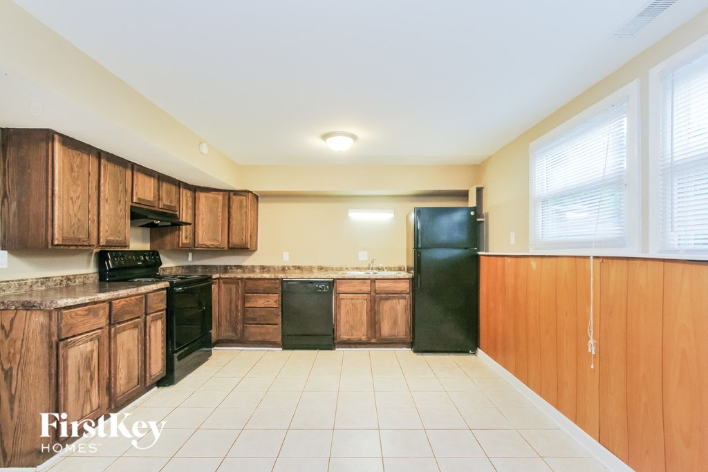 a kitchen with wooden cabinets and black appliances