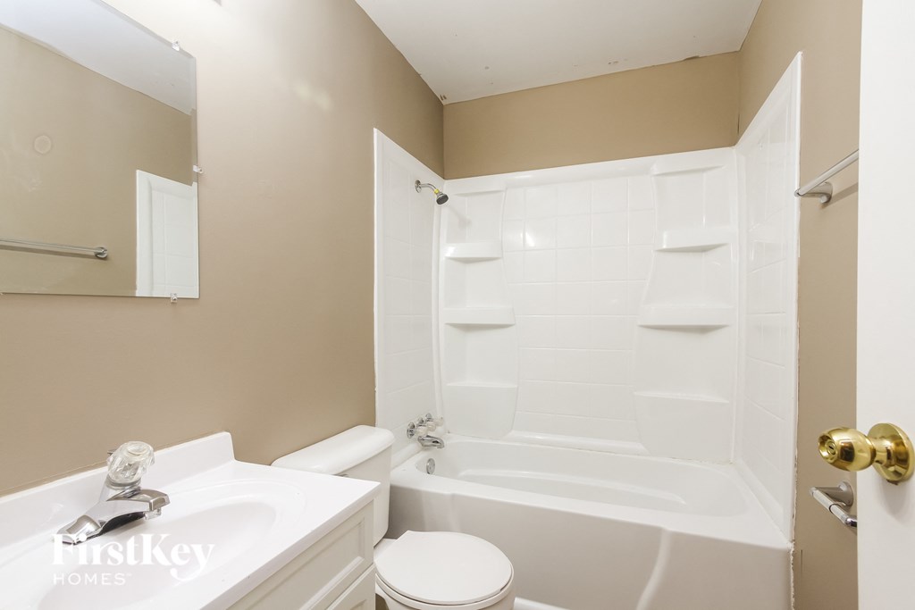 a white bathroom with a tub and a sink and a toilet