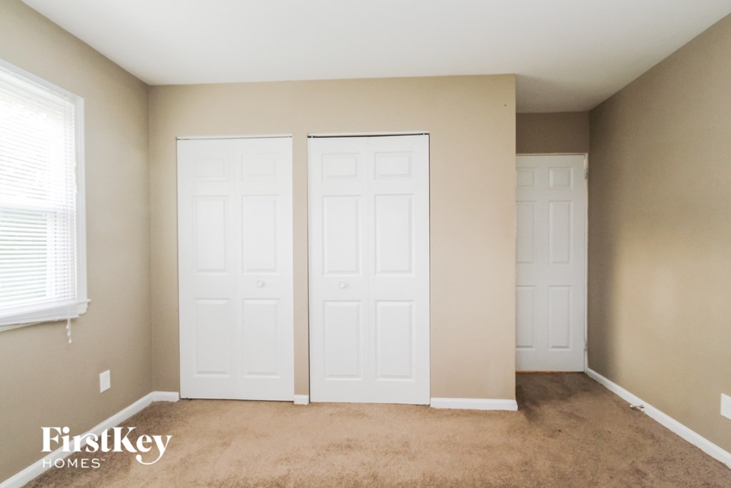 a bedroom with two white doors and a carpeted floor