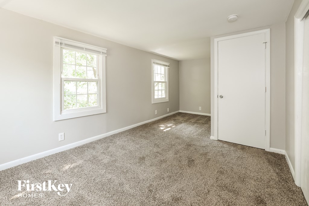 a bedroom with a carpeted floor and a white door