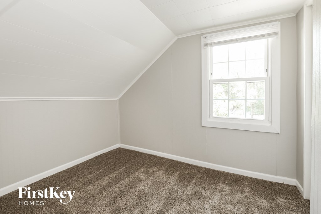 a small room with a window and a carpeted floor
