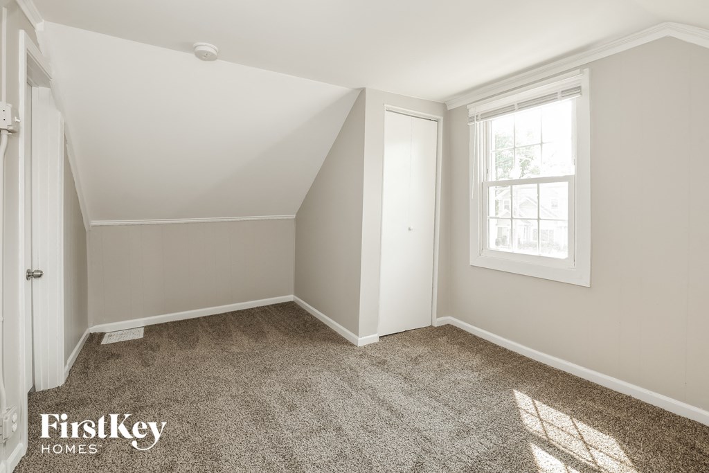 a bedroom with a carpeted floor and a window