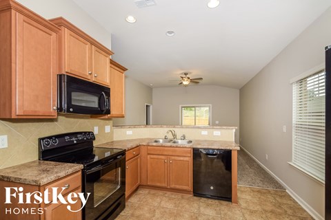 A kitchen with wooden cabinets and black appliances.