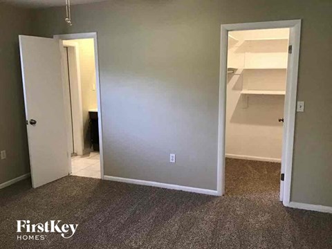 a bedroom with a closet and an open door to a bathroom