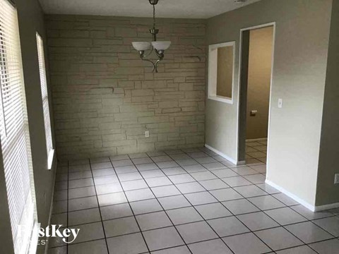 a living room with a tile floor and a brick wall