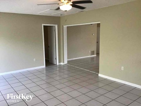 an empty living room with a ceiling fan