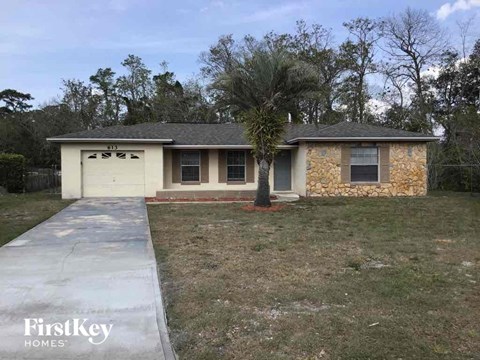a home with a driveway and a tree in front of it