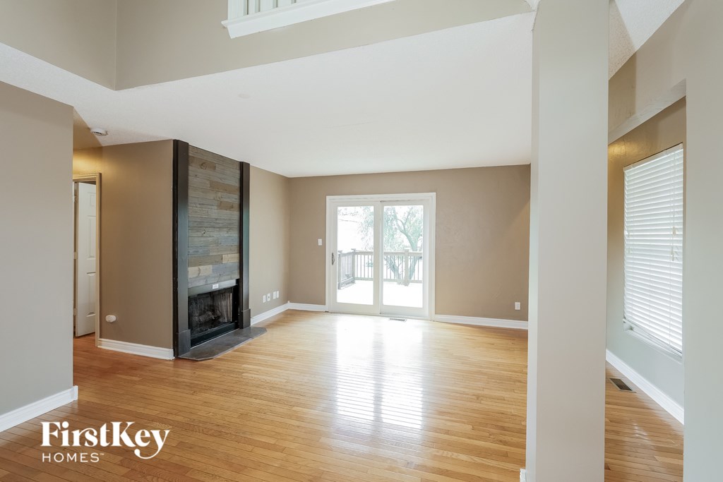 A spacious room with wooden floors and a skylight.