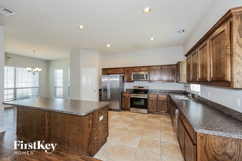 A kitchen with wooden cabinets and a granite countertop.