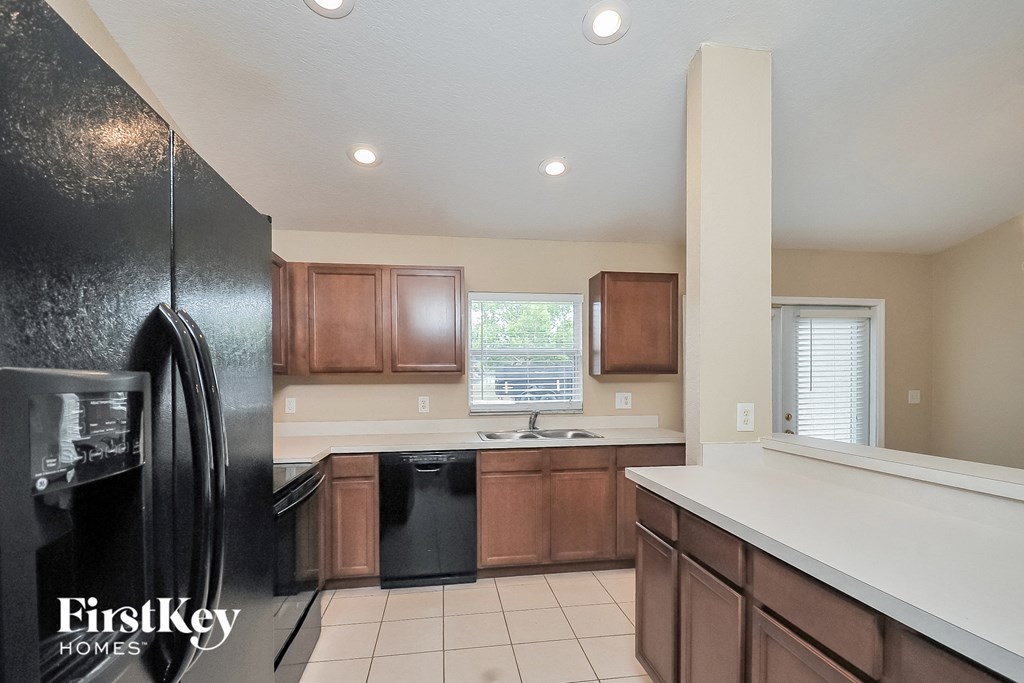 the kitchen is clean and ready to use with black appliances and white countertops