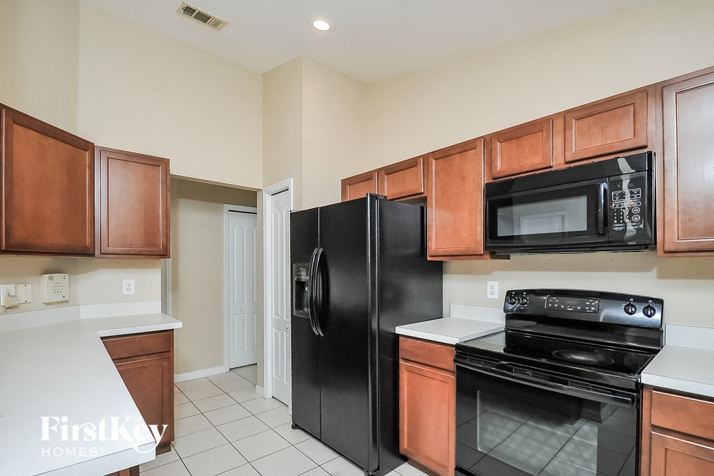 a kitchen with black appliances and wooden cabinets