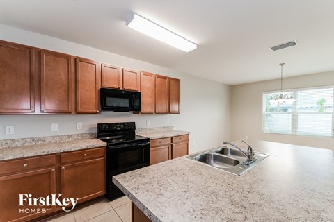 a kitchen with wood cabinets and granite counter tops and a sink