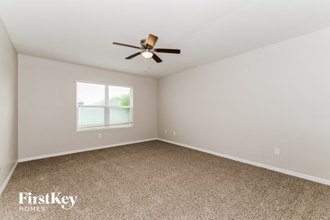 a bedroom with carpet and a ceiling fan