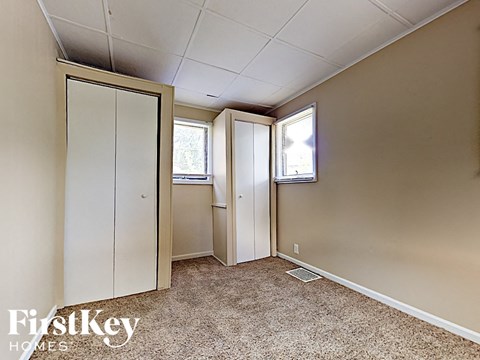 a small bedroom with a closet and a window