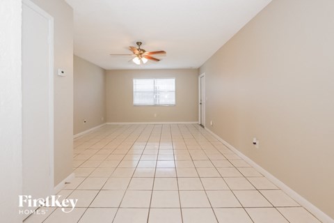 A spacious room with a ceiling fan and a window.