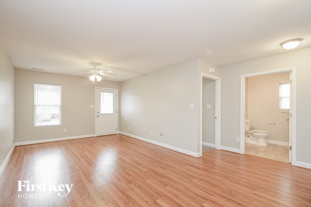 a living room with a hard wood floor and a ceiling fan