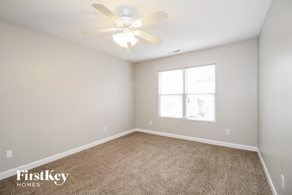 a bedroom with carpet and a ceiling fan